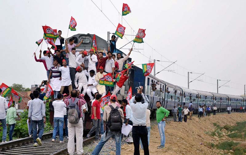 Samajwadi Party workers block a train in protest against hike in railway fares, in Allahabad.