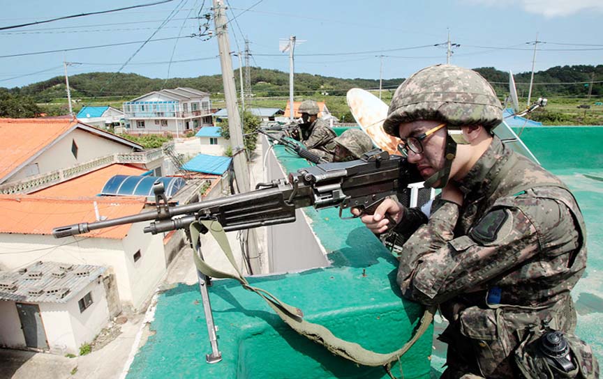 South Korean army soldiers aim their machine guns as they search for a South Korean conscript soldier who is on the run after a shooting incident in Goseong, South Korea.