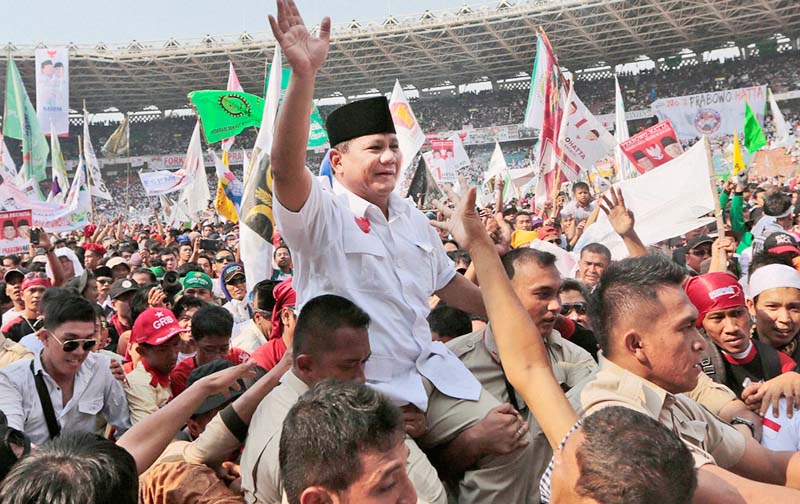 Indonesian presidential candidate Prabowo Subianto, center, is carried by his bodyguards as he greets his supporters during a campaign rally at Gelora Bung Karno Stadium in Jakarta, Indonesia.