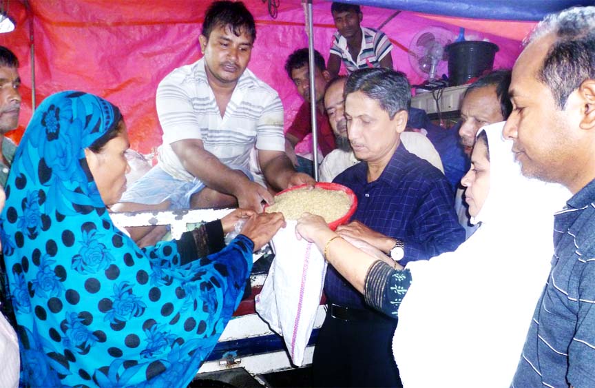 CDA Chairman Abdus Salam distributing relief goods among the flood affected people in Bakolia, Chittagong .Women Councellor Shaheda Kasem Shathi was present during the distribution.