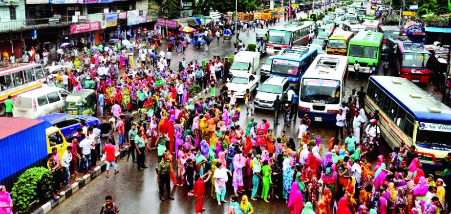 Workers of an Apparels factory put barricade on road in city's Kallyanpur area on Sunday demanding payment of outstanding salaries.