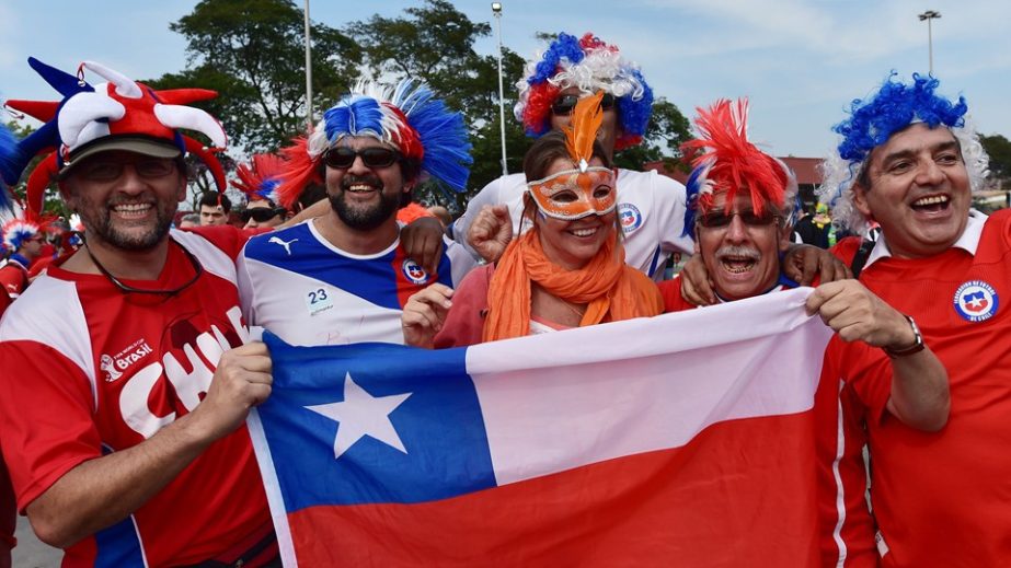 Chile fans cheer with a Netherlands' fan (C) outside the Corinthians Arena in Sao Paulo as they arrive for the Group B football match between Netherlands and Chile during the 2014 FIFA World Cup on Monday.