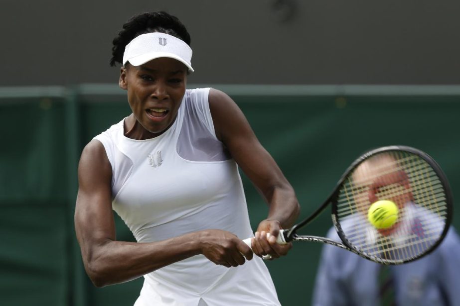 Venus Williams of the US plays a return to Maria-Teresa Torro-Flor of Spain during their first round match at the All England Lawn Tennis Championships in Wimbledon, London on Monday.