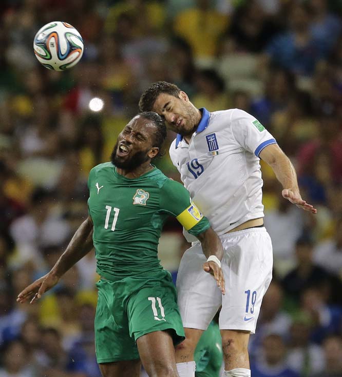 Ivory Coast's Didier Drogba goes up against Greece's Sokratis Papastathopoulos to head the ball during the group C World Cup soccer match between Greece and Ivory Coast at the Arena Castelao in Fortaleza, Brazil on Tuesday.