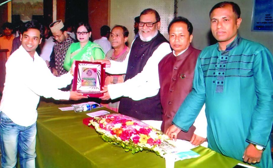 Md Rafiqul Islam Bakul, Managing Director of Dolphin Washing Plant, receiving Mother Teresa Honorary award 2014 from AKM Mozammel Haq, Minister for Liberation War Affairs at Public Library auditorium recently.