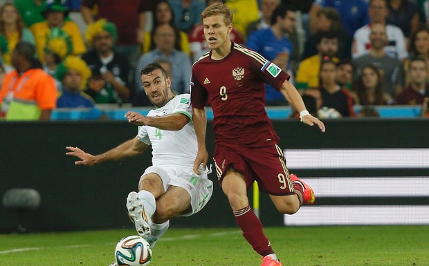 Algeria's Essaid Belkalem (L) fights for the ball with Russia's Alexander Kokorin during their 2014 World Cup Group H soccer match at the Baixada arenain