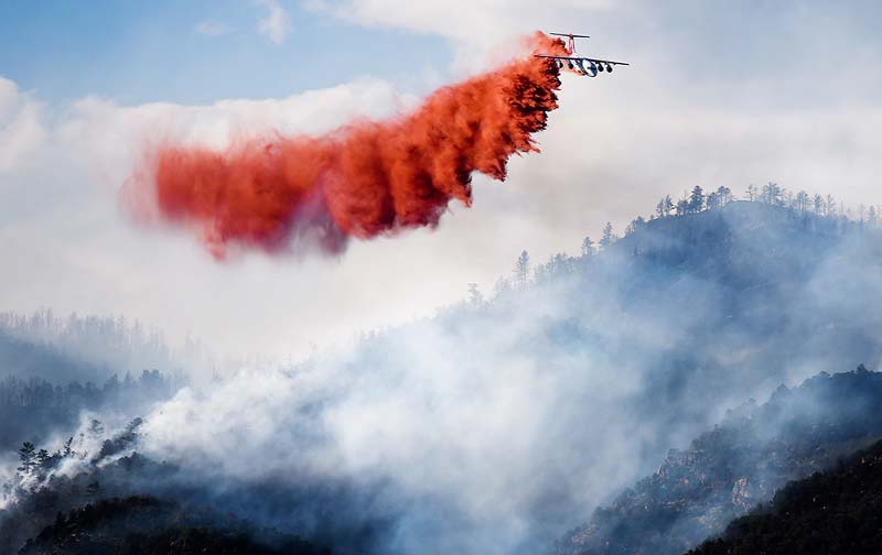 A slurry bomber makes a drop on the Eightmile Fire, north of Canon City, Colo. Fire information officer Dusty Romero said fire managers on scene have requested at least an additional 80 firefighters.