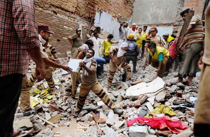Rescue workers clear debris at the site of a building collapse in New Delhi, India on Saturday. A dilapidated building collapsed in the Indian capital on Saturday, killing at least seven people as rescuers searched for others believed to be trapped.