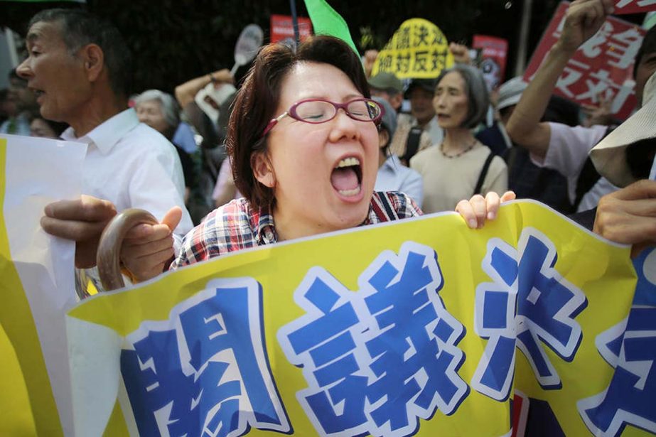 People protest outside the Japanese prime minister's office in anticipation his government will reinterpret the constitution to allow Japan's military a larger international role in Tokyo on Tuesday.