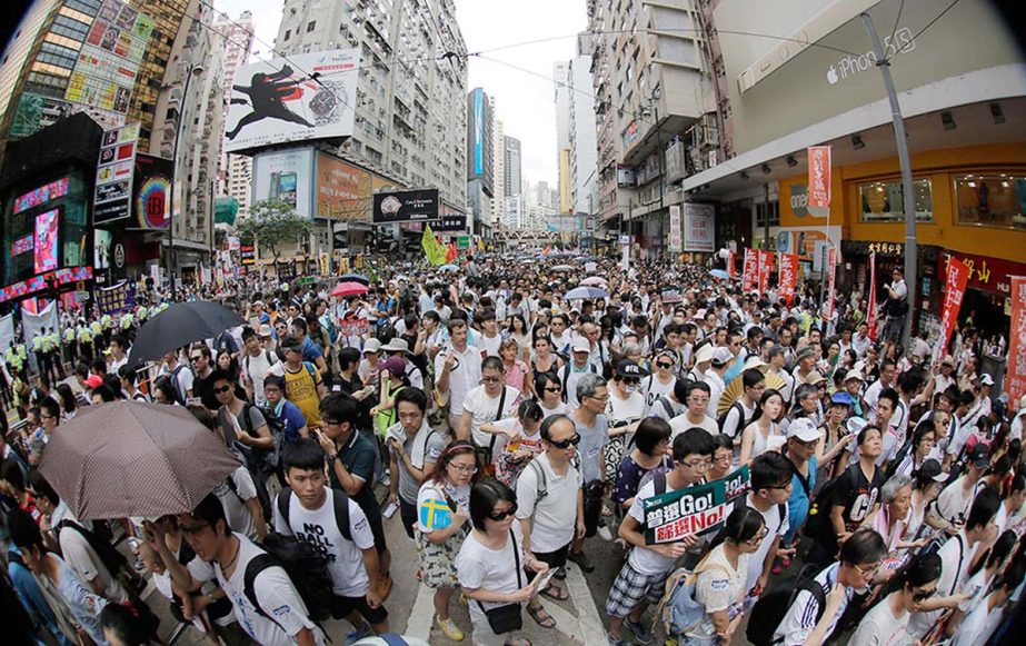 People fill in a street during a march at an annual protest in downtown Hong Kong. Tens of thousands of Hong Kong residents marched through the streets of the former British colony to push for greater democracy in a rally fueled by anger over Beijing's r
