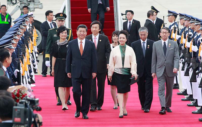 Chinese President Xi Jinping, foreground left, and Chinese first lady Peng Liyuan, foreground right, inspect an honor guard upon their arrival at Seoul Military Airport in Seongnam, South Korea.