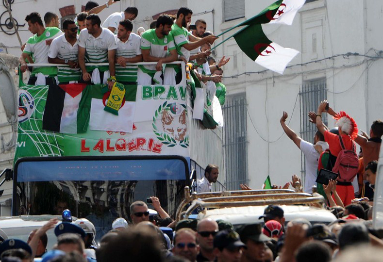Algerian national team players are greeted by fans upon their return from Brazil on Wednesday in the capital Algiers. Extra-time goals by Andre Schuerrle and Mesut Ozil sealed Germany's 2-1 win over Algeria in the last 16 clash to put the three-time winn