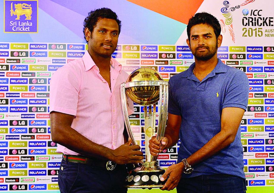 Angelo Mathews and Lahiru Thirimanne pose with the 2015 World Cup trophy at Colombo on Friday.