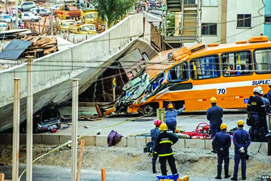 Firefighters and policemen work at the site where several vehicles were crushed by a highway overpass that collapsed in Belo Horizonte, Brazil, on Thursday.
