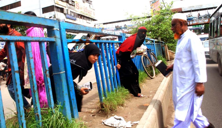 In spite of an over bridge near by shoppers including women and elderly persons venture to cross the busy city street through the damaged portion of the road divider fencing. The don't care-attitude of the road users is the main cause of frequent acciden