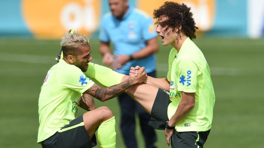 Brazil's defender David Luiz (R) and Brazil's defender Dani Alves stretch as they take part in a training session at the Granja Comary training complex in Teresopolis during the 2014 FIFA World Cup in Brazil on Monday. Brazil will play against Germany i