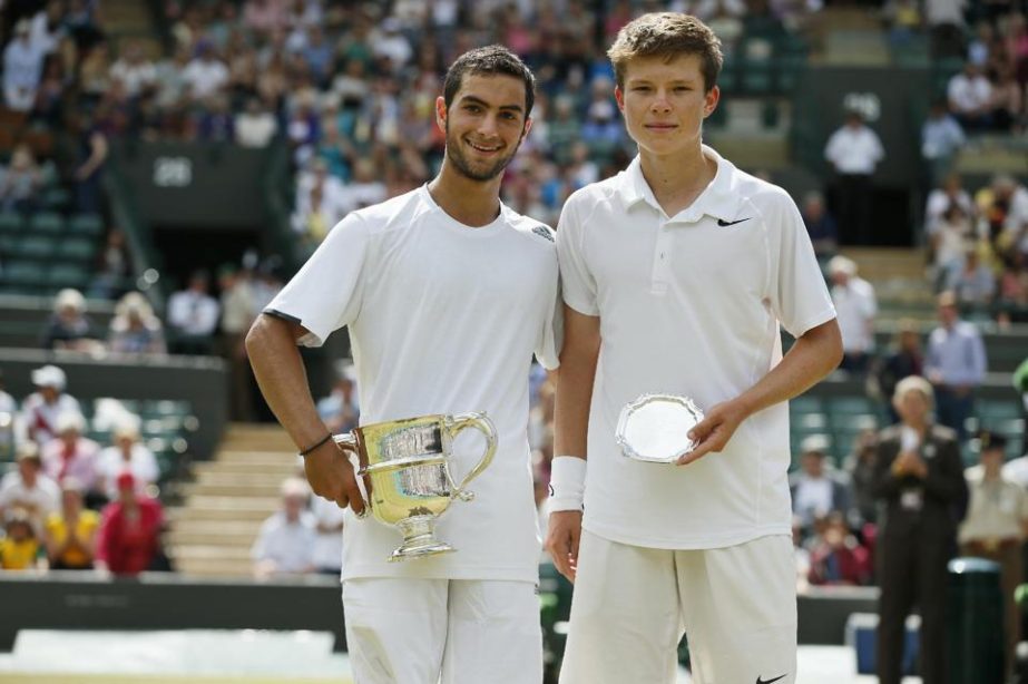 Noah Rubin of the US (left) holds the trophy after defeating Stefan Kozlov of the US (right) in the boys' singles final at the All England Lawn Tennis Championships in Wimbledon, London on Sunday.