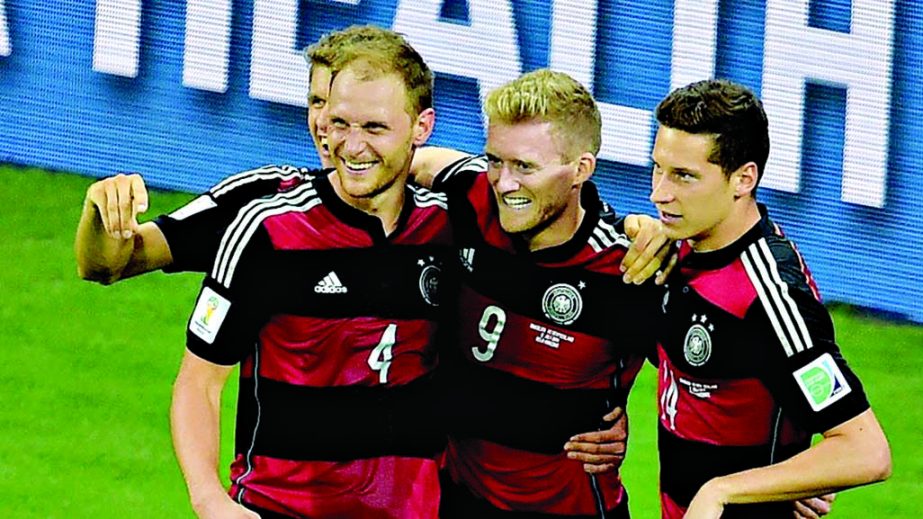 Germany's forward Andre Schuerrle celebrates with Germany's defender Benedikt Hoewedes and Germany's midfielder Julian Draxler after scoring his second goal, Germany's seventh during the semi-final football match of 2014 FIFA World Cup between Brazil