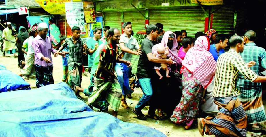 A burqa-clad woman with her infant on arms (Circled) running helter and skelter on Mirpur Road to escape police action against agitating garment workers who blocked some roads in the area on Saturday demanding payment of salary and bonus ahead of Eid holi