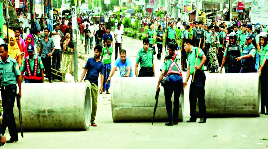 Police clearing blockades put up on Mirpur Road on Saturday by garment workers in support of their demand for salary and bonus on the occasion of Eid-ul Fitr.