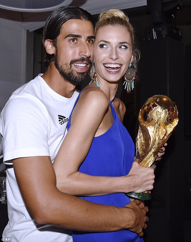 Hold on tight: Sami Khedira and his girlfriend Lena Gercke with the World Cup trophy in their grasp.