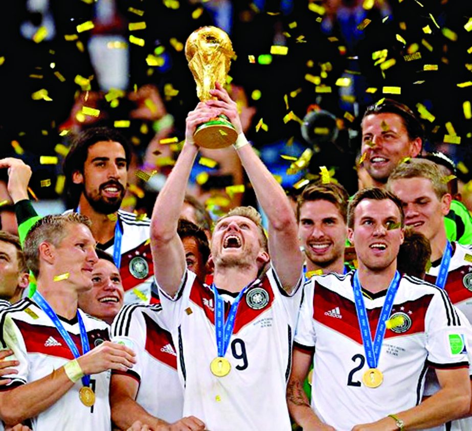 Andre Schuerrle of Germany lifts the World Cup trophy to celebrate with his teammates during the award ceremony after the 2014 FIFA World Cup Brazil final match against Argentina at Maracana in Rio de Janeiro on Sunday night.