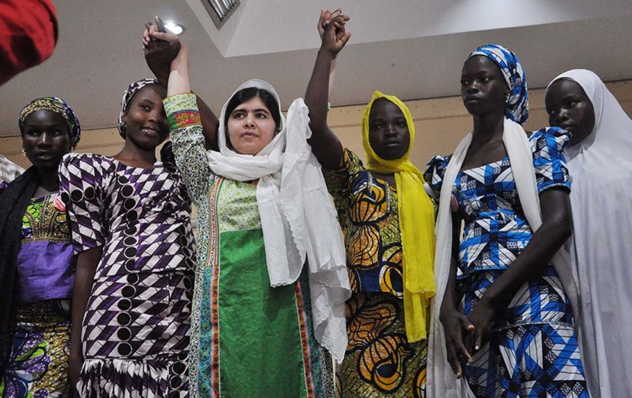 Pakistani activist Malala Yousafzai, centre, raises her hands with some of the escaped kidnapped school girls of government secondary school Chibok during a news confrence, in Abuja, Nigeria.