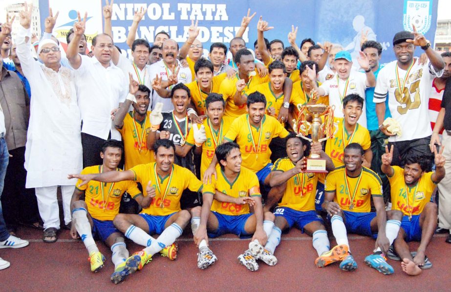 Members of Sheikh Jamal Dhanmondi Club, the champions of the Nitol Tata Bangladesh Premier Football League pose with the trophy at the Bangabandhu National Stadium on Tuesday.