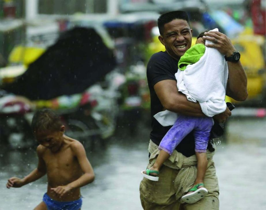 Residents at the slum community of Baseco evacuate to safer grounds at the onslaught of Typhoon Rammasun (locally known as Glenda) which battered Manila Wednesday.