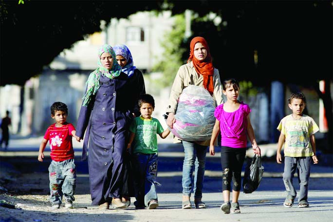 Palestinians flee their homes in the Zeitoun neighbourhood of Gaza City, after Israel had airdropped leaflets warning people to leave the area on Wednesday.