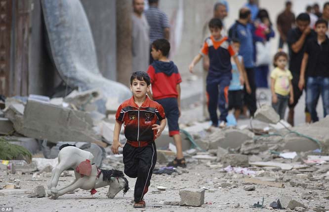 A Palestinian child runs on debris from a destroyed house, following an overnight Israeli strike in Beit Lahiya, in the north of the Gaza strip this morning. 40,000 people have been displaced from their homes by Israeli bombing and a ground offensive