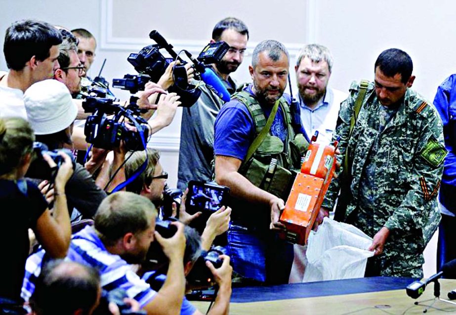 Crucial evidence: Pro-Russian separatists finally hand over the two black boxes from MH17 to Colonel Mohamed Sakri (not pictured) of Malaysian National Security Council during a press conference in Donetsk.