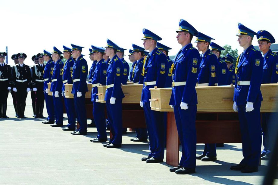 Honour guards carry coffin of the victims of Malaysia Airlines MH17 downed over rebel-held territory in eastern Ukraine for loading on to a transport plane heading to the Netherlands at Kharkiv airport.