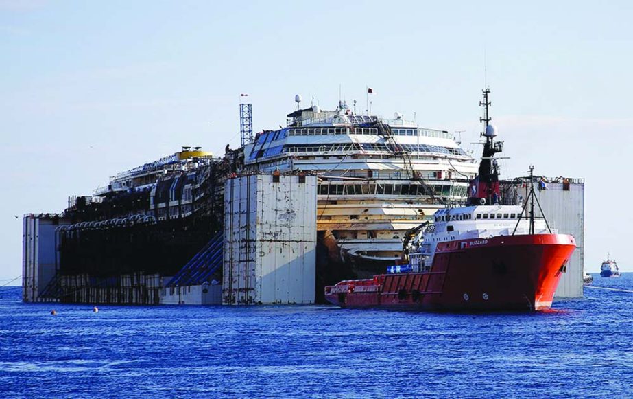 The Costa Concordia cruise wreck is maneuvered into position to be towed away from the tiny Tuscan island of Isola del Giglio, Italy.