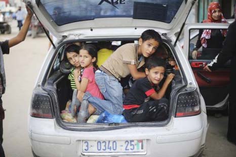 Palestinian children sit in a car boot as they flee their family homes following heavy Israeli shelling during an Israeli ground offensive east of Khan Younis, in the southern Gaza Strip.