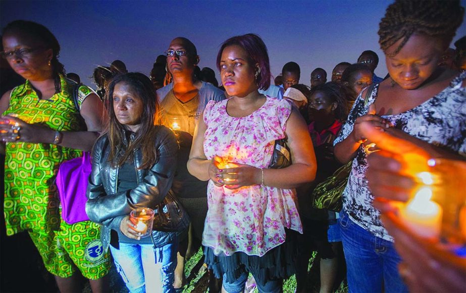 Mourners gather for a vigil at a park in Longueuil, Quebec, Canada in memory of the victims of Air Algerie Flight 5017.