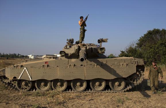 An Israeli soldier checks his weapon atop a tank near the border with Gaza July 27, 2014. Credit: ReutersSiegfried Modola