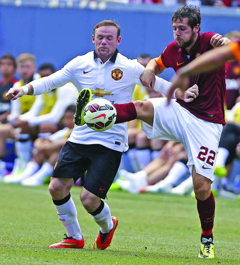 Manchester United's Wayne Rooney (left) and AS Roma's Mattia Destro fight for control of the ball during an exhibition soccer match at Mile High Stadium in Denver on Saturday. Manchester United won 3-2.