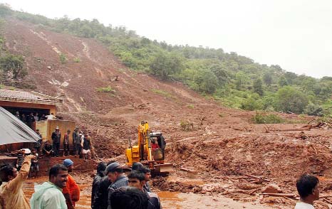 A rescuer clears debris with the help of an excavator at the site of a landslide in Malin village, in the western Indian state of Maharashtra.