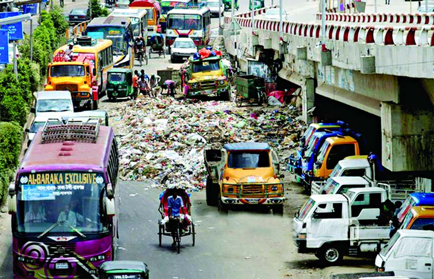 Authorities unconcern: With garbage stream all over the commuters and vehicles struggling to pass the road under Kuril Flyover on Saturday.