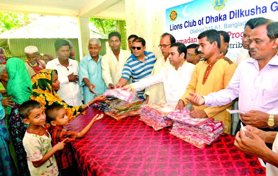 Former President of Lions Club of Dhaka Dilkusha Green Ln Mohammad Mizanur Rahman distributing clothes among the poor and distressed people of Radhanagar village in Araihazar Upazila of Narayanganj recently.