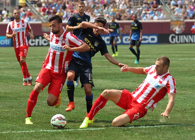 Manchester City midfielder Jesus Navas (15) (center) is converged on by Olympiacos forward Kevin Mirallas (14) (left) and Olympiacos defender Giannis Maniatis (2) during the first half of the Guinness International Champions Cup at TCF Bank Stadium on the