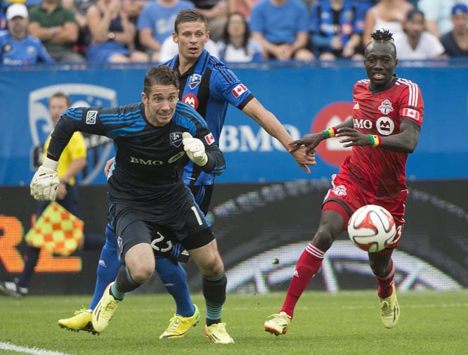 Montreal Impact's goalkeeper Troy Perkins (left) scrambles for the ball as Impact's Krzysztof Krol and Toronto FC's Dominic Oduro (right) look on, during the second half of a soccer match in Montreal on Saturday.