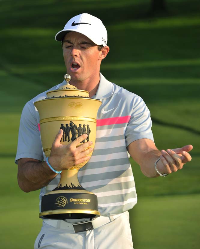 Rory McIlroy, of Northern Ireland stretches his arm after holding the championship trophy during photo opportunities after winning the Bridgestone Invitational golf tournament in Akron, Ohio on Sunday. McIlroy won with a final round 66 to beat Sergio Garc