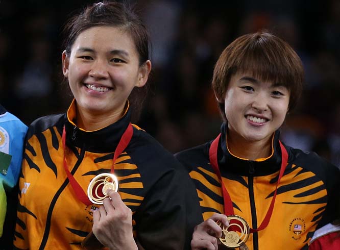 Malaysia's Khe Wei Woon (left) and Vivian Kah Mun Hoo (right) pose with their gold medals after their victory over India's Jwala Gutta and Ashwini Ponnappa at the end of their women's doubles Badminton match at the Emirates Arena during the Commonwealt