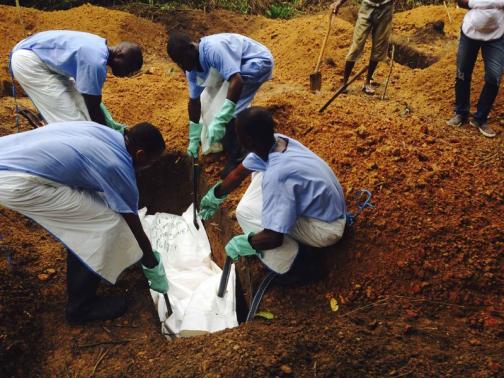 Volunteers prepare to remove the bodies of people who were suspected of contracting Ebola and died in the community in the village of Pendebu, north of Kenema.