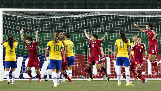 China's Zhu Zhang (11), Jiali Tang (10), Mengwen Li (13) and Siqi Lyu (5) celebrate a goal against Brazil during the second half of a FIFA U-20 women's World Cup soccer match in Edmonton, Alberta on Tuesday.