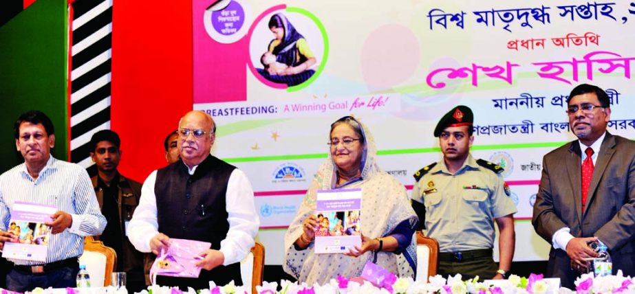 Prime Minister Sheikh Hasina along with other distinguished persons holds the copies of a book titled 'Ma O Shishu' at its cover unwrapping ceremony at Osmani Memorial Auditorium in the city on Wednesday on the inauguration ceremony of World Breastfeedi