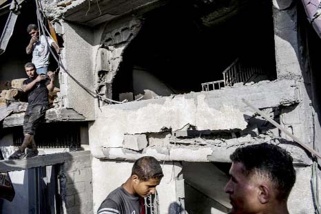 Palestinian boys gather in front of their destroyed home in the devastated neighbourhood of Shejaiya in Gaza City.