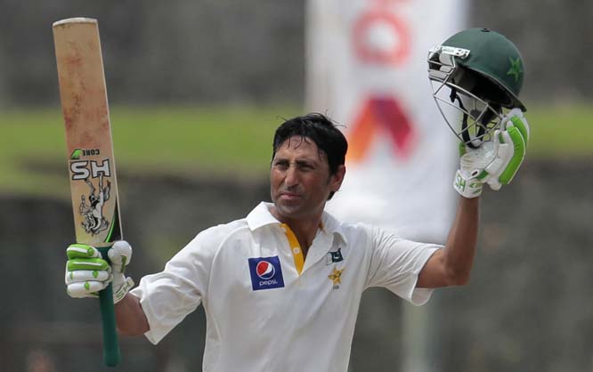 Pakistani cricketer Younis Khan raises his bat and helmet to acknowledge the crowd after scoring 150 runs during the second day of the first test cricket match between Sri Lanka and Pakistan in Galle, Sri Lanka on Thursday.
